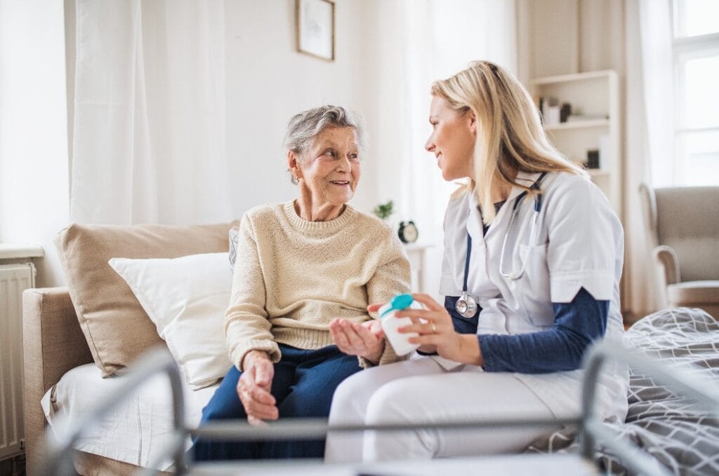 A health visitor explaining a senior woman how to take pills.